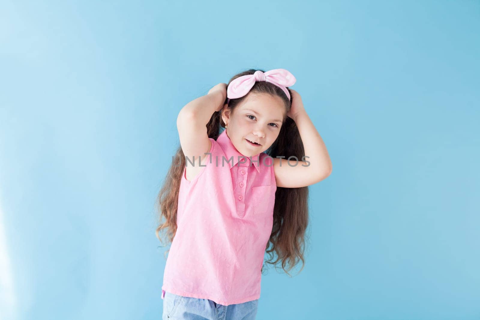 little girl holds her hair with her hands