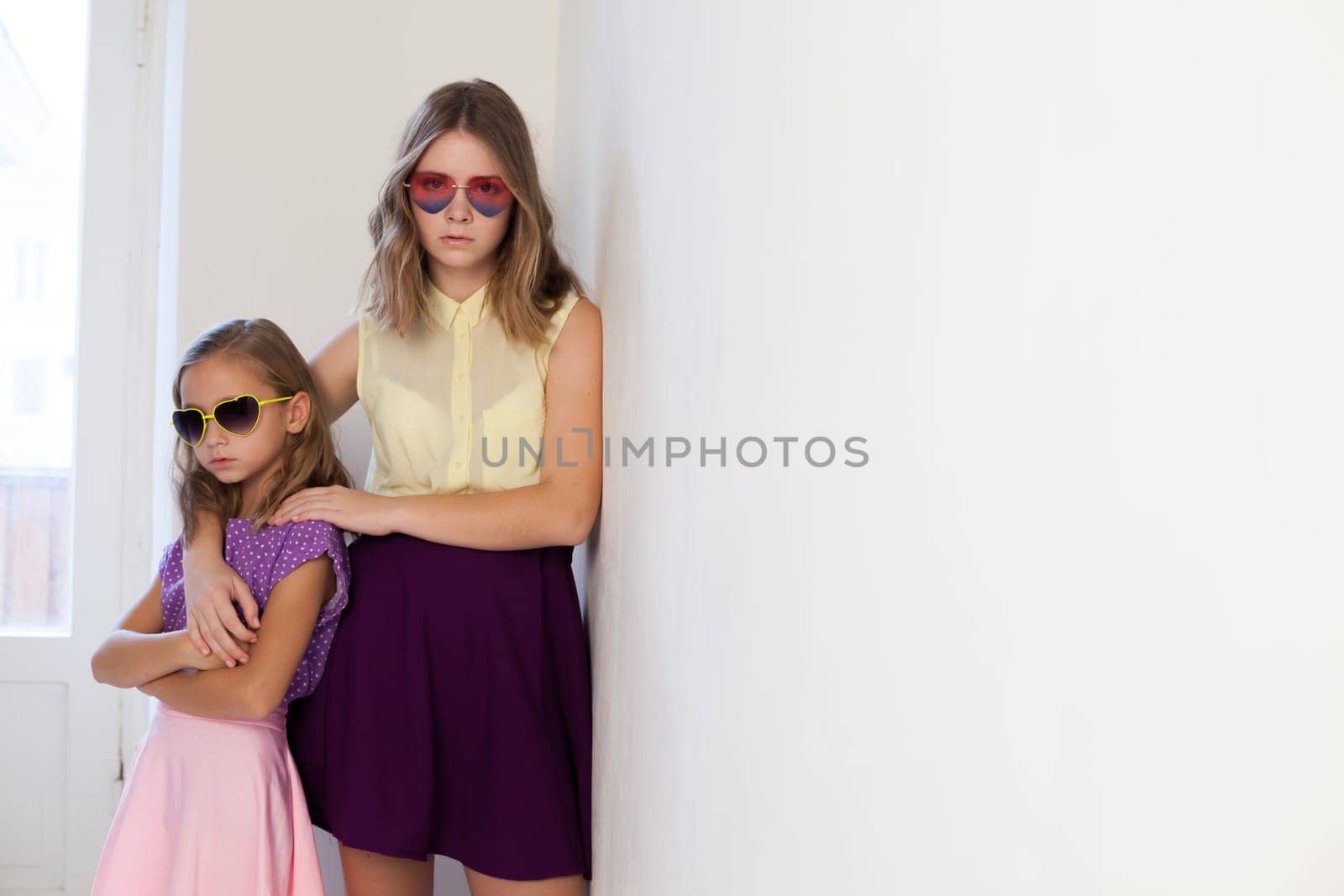 Two fashionable little sister girls of different ages by Simakov