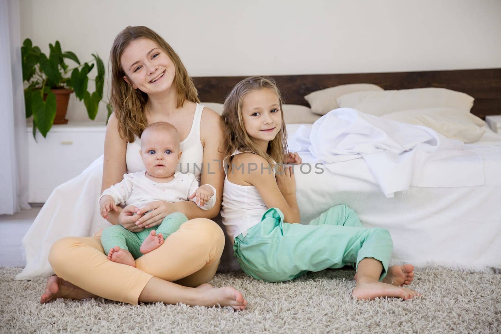 three girls sisters of different ages in the morning in the bedroom without parents
