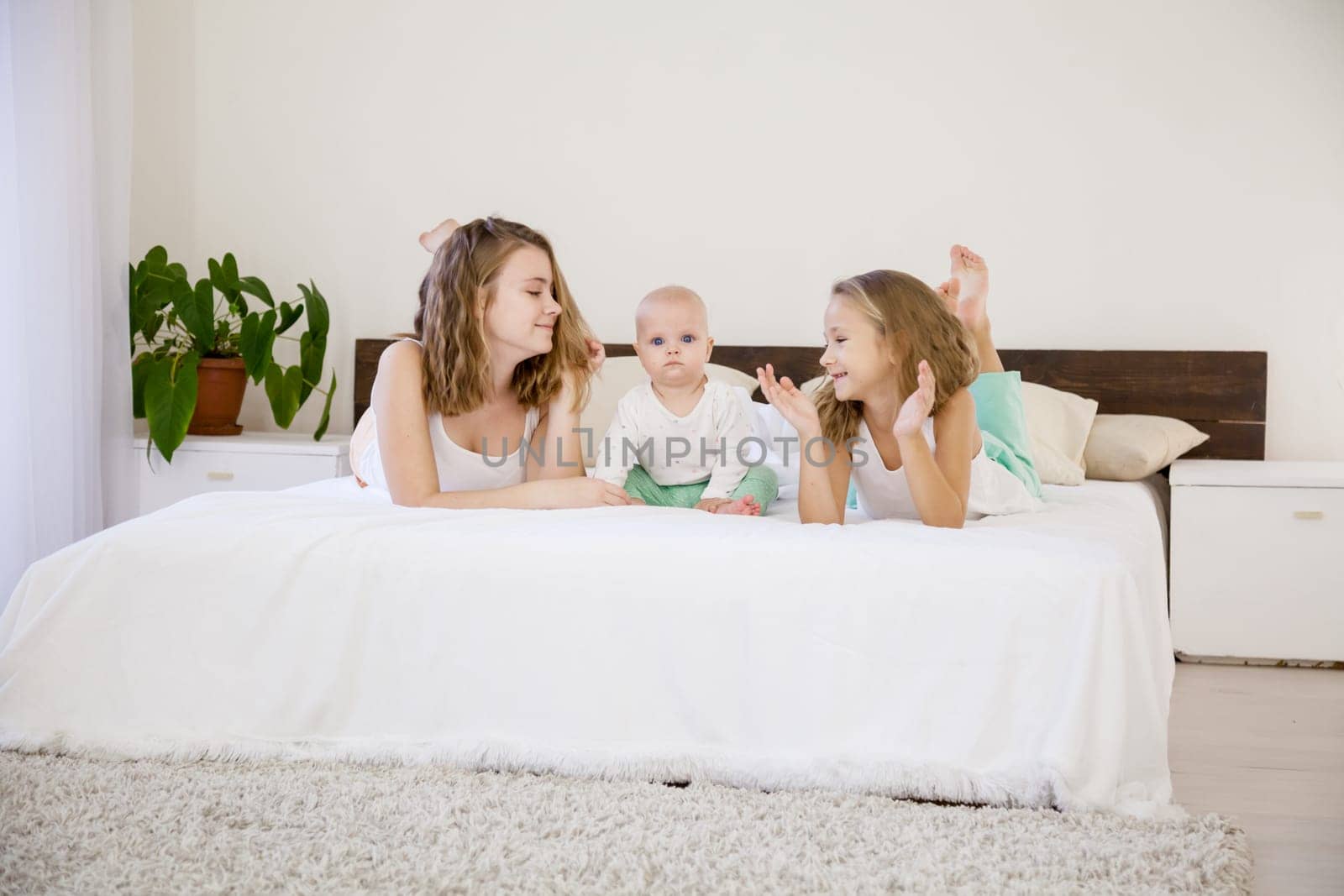 three girls sisters of different ages in the morning in the bedroom without parents