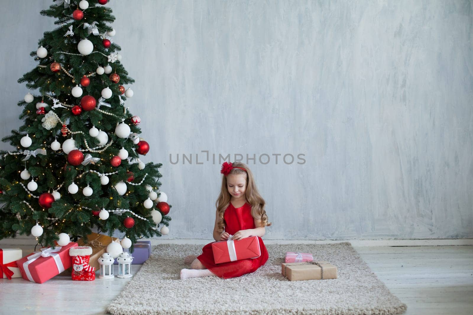 girl decorates Christmas tree gifts new year