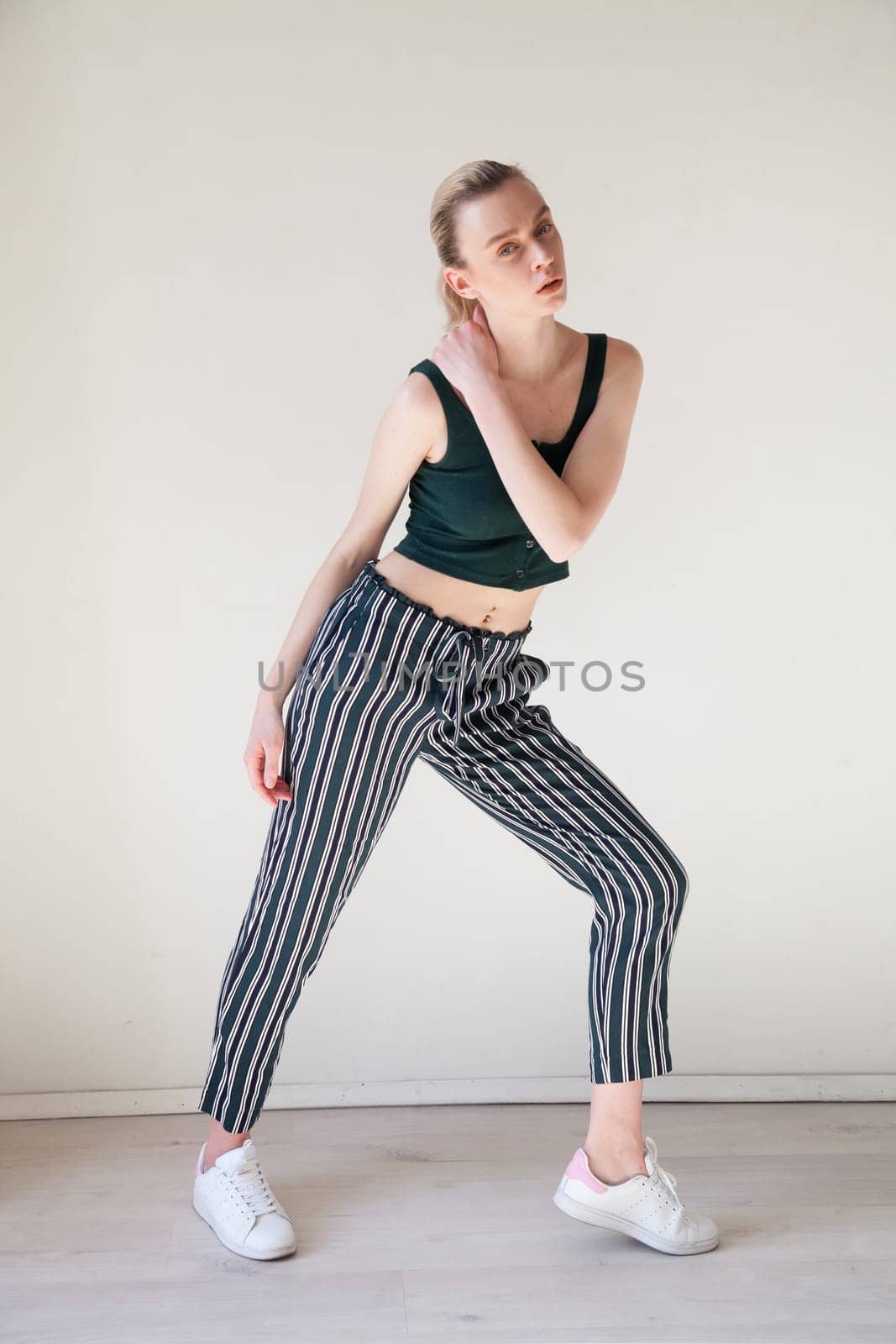 Portrait of a blonde woman in striped pants