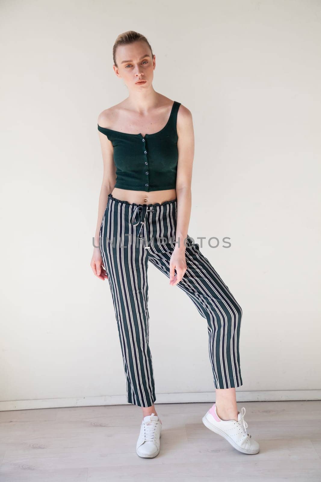 Portrait of a beautiful blonde woman in striped pants by Simakov