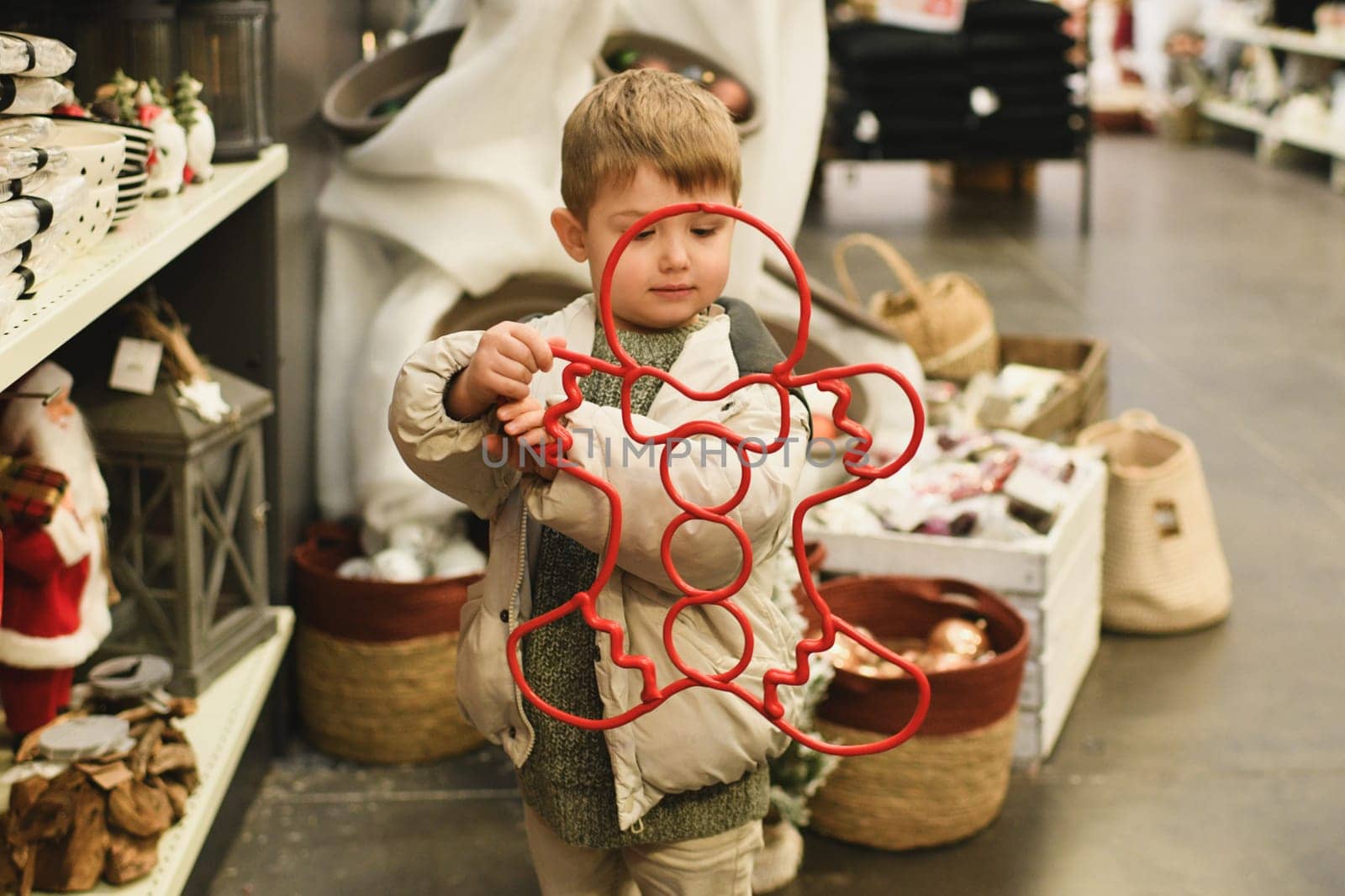 A boy chooses decorations in the shape of a gingerbread man