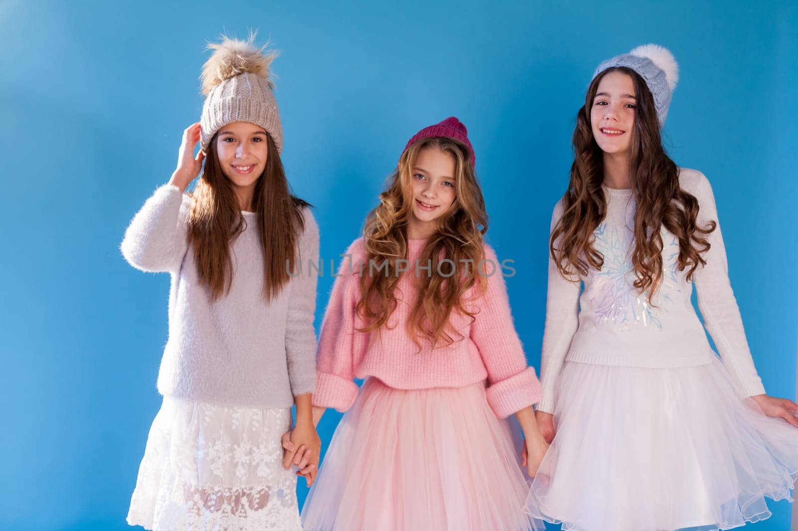 portrait of three beautiful little girls in a winter hat