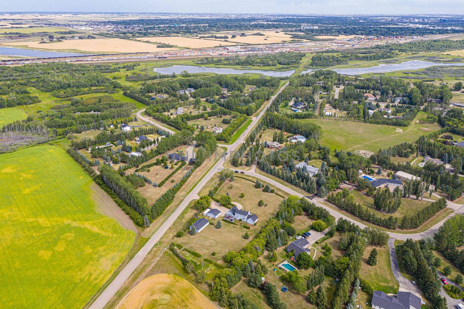 Experience the charm of Cedar Villa Estates from above. This drone image beautifully showcases the area's spacious estates, lush greenery, and tranquil setting, offering a unique aerial perspective of Saskatoon.