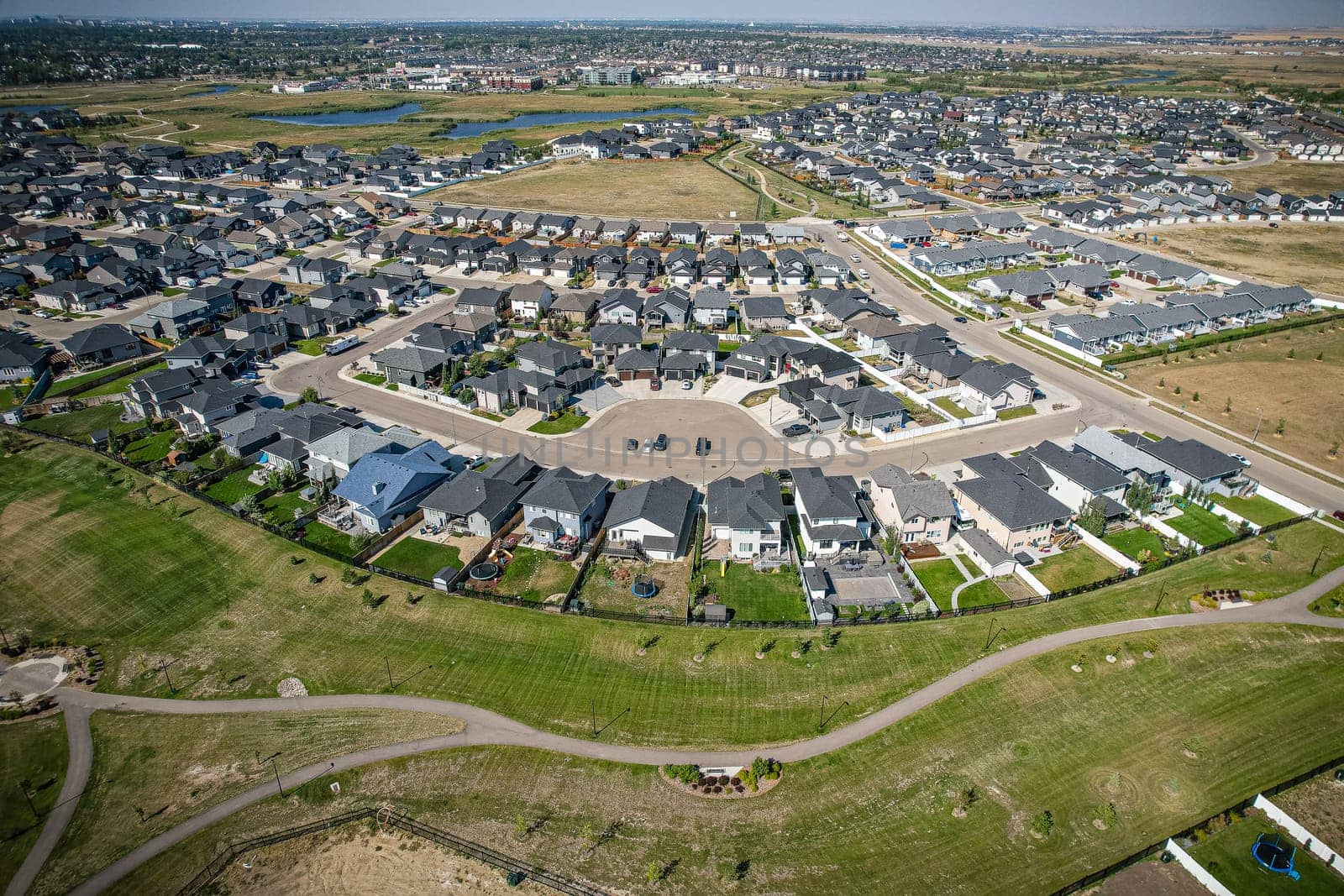 Elevated view of Rosewood neighborhood in Saskatoon, presenting a tapestry of urban design intertwined with Saskatchewan's serene natural canvas.