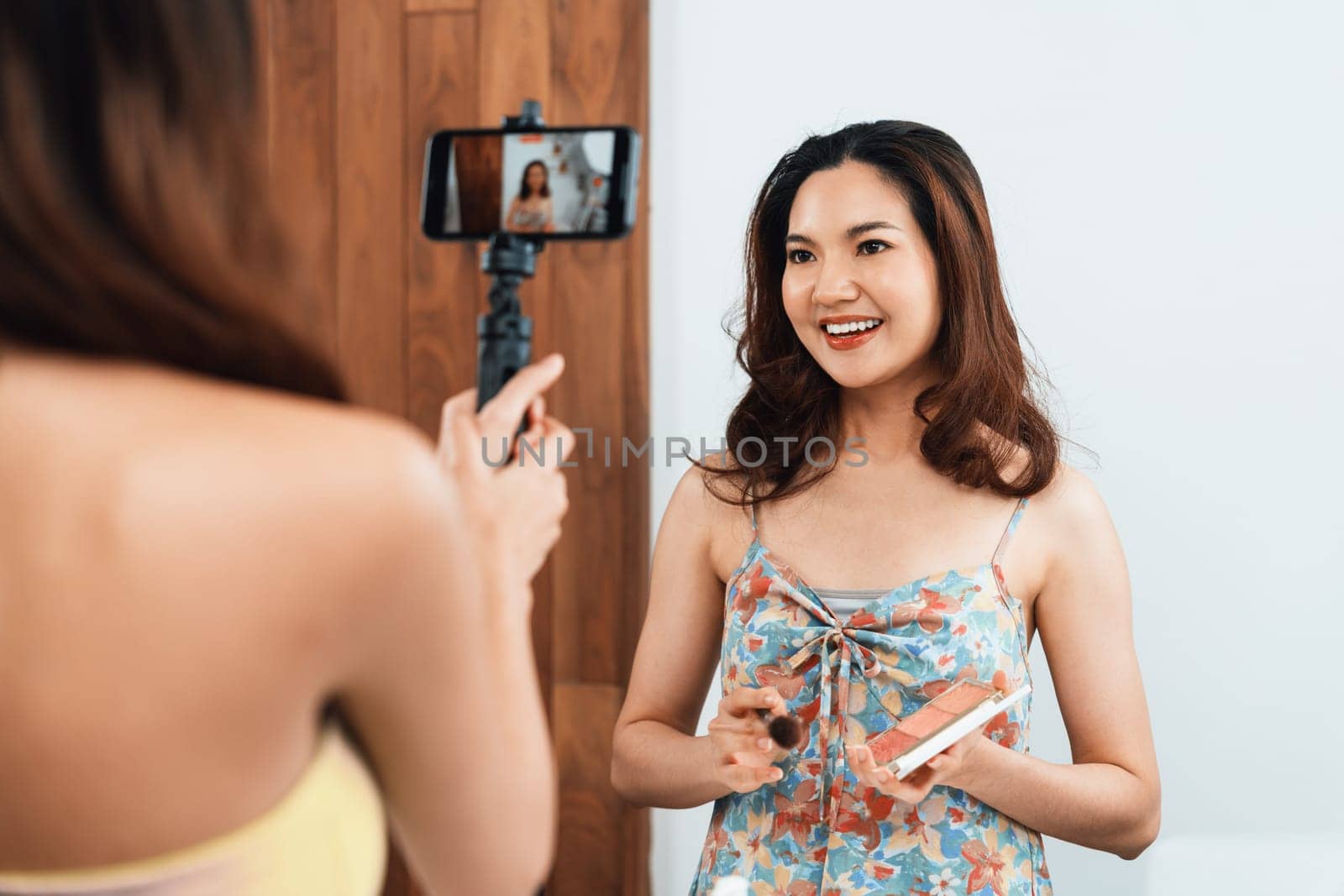 Woman influencer shoot live streaming vlog video review makeup uttermost social media or blog. Happy young girl with cosmetics studio lighting for marketing recording session broadcasting online.