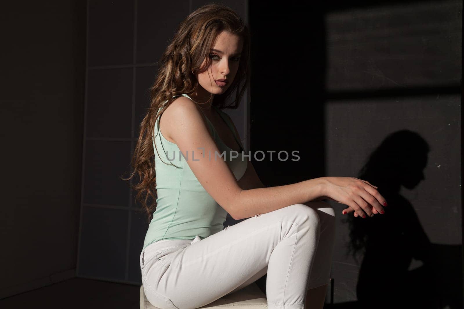 Portrait of a beautiful woman with long hair sitting on the floor by Simakov