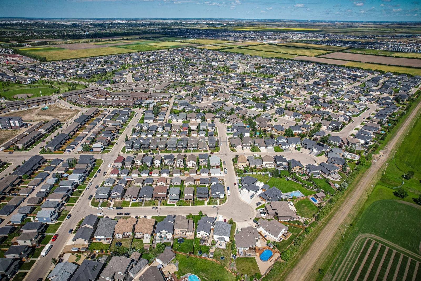 Elevated panorama of Willowgrove, showcasing the neighborhood's modern aesthetics intertwined with pockets of lush green, epitomizing Saskatoon's suburban beauty