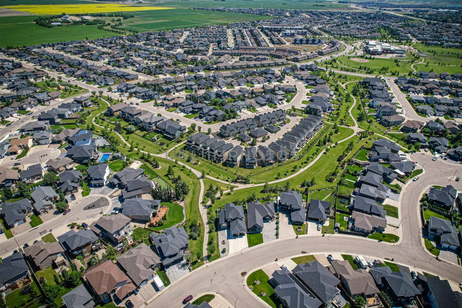 Elevated panorama of Willowgrove, showcasing the neighborhood's modern aesthetics intertwined with pockets of lush green, epitomizing Saskatoon's suburban beauty