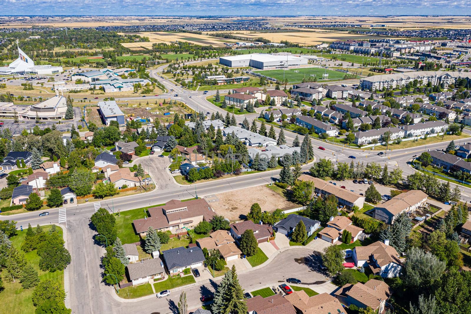 Explore the lush Forest Grove neighborhood in Saskatoon from an aerial perspective. This drone image captures the area's verdant charm, peaceful streets, and community warmth, under the vast Saskatchewan sky.
