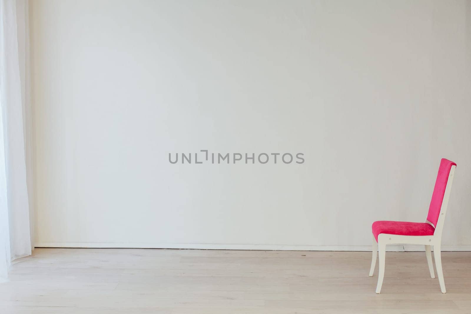 pink chair in the interior of an empty white room by Simakov