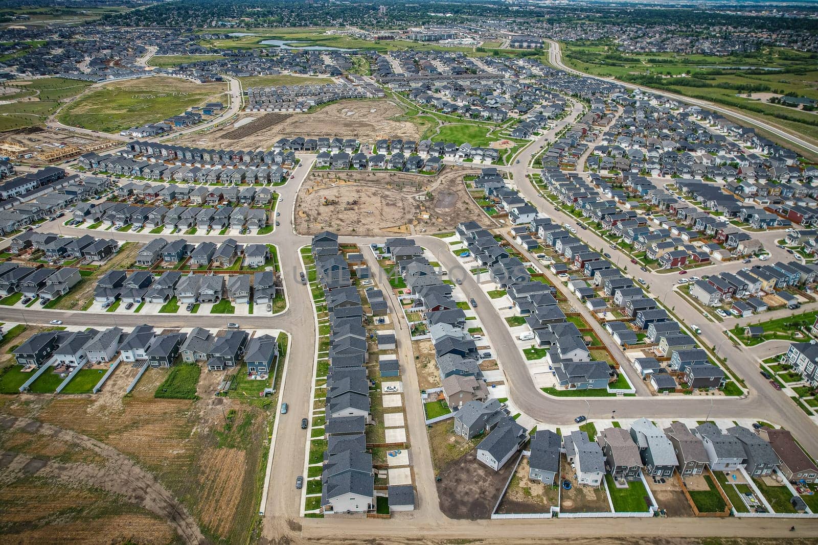 Elevated view of Rosewood neighborhood in Saskatoon, presenting a tapestry of urban design intertwined with Saskatchewan's serene natural canvas.