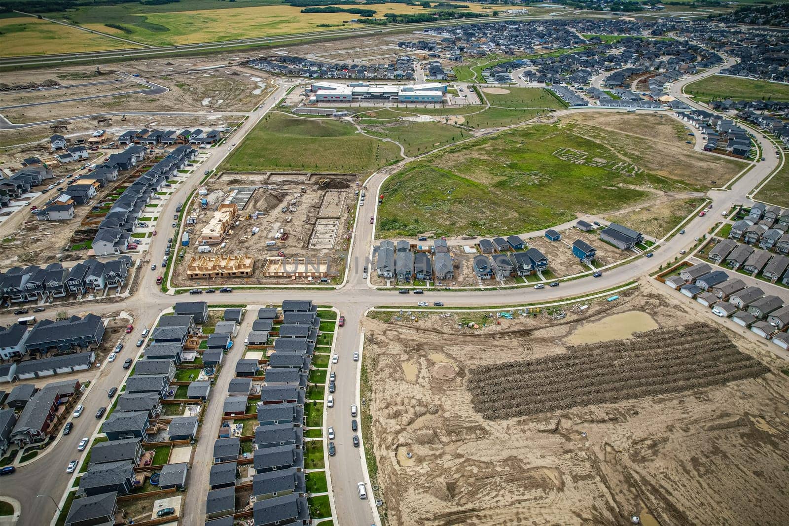 Elevated view of Rosewood neighborhood in Saskatoon, presenting a tapestry of urban design intertwined with Saskatchewan's serene natural canvas.