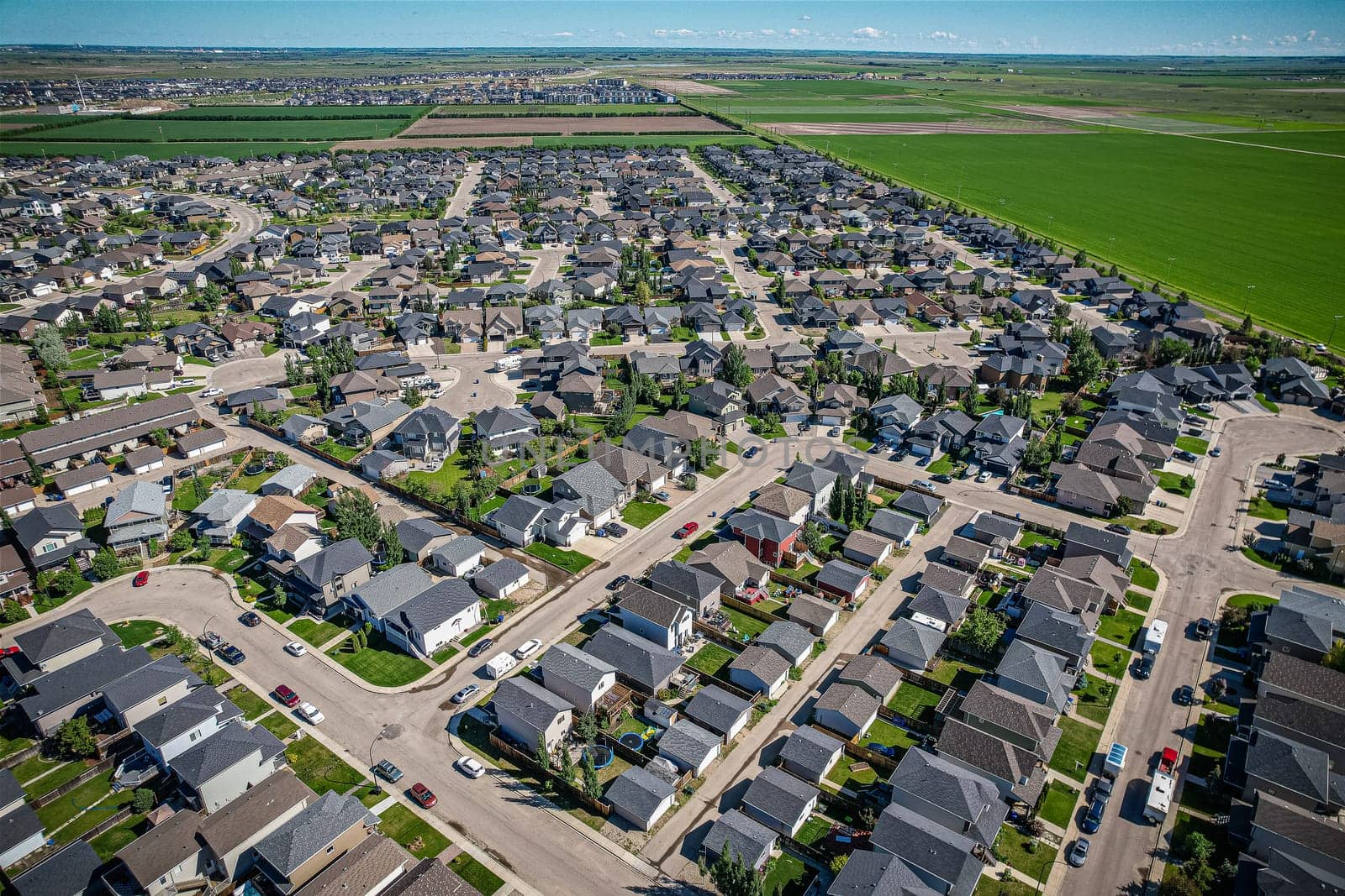 Elevated panorama of Willowgrove, showcasing the neighborhood's modern aesthetics intertwined with pockets of lush green, epitomizing Saskatoon's suburban beauty