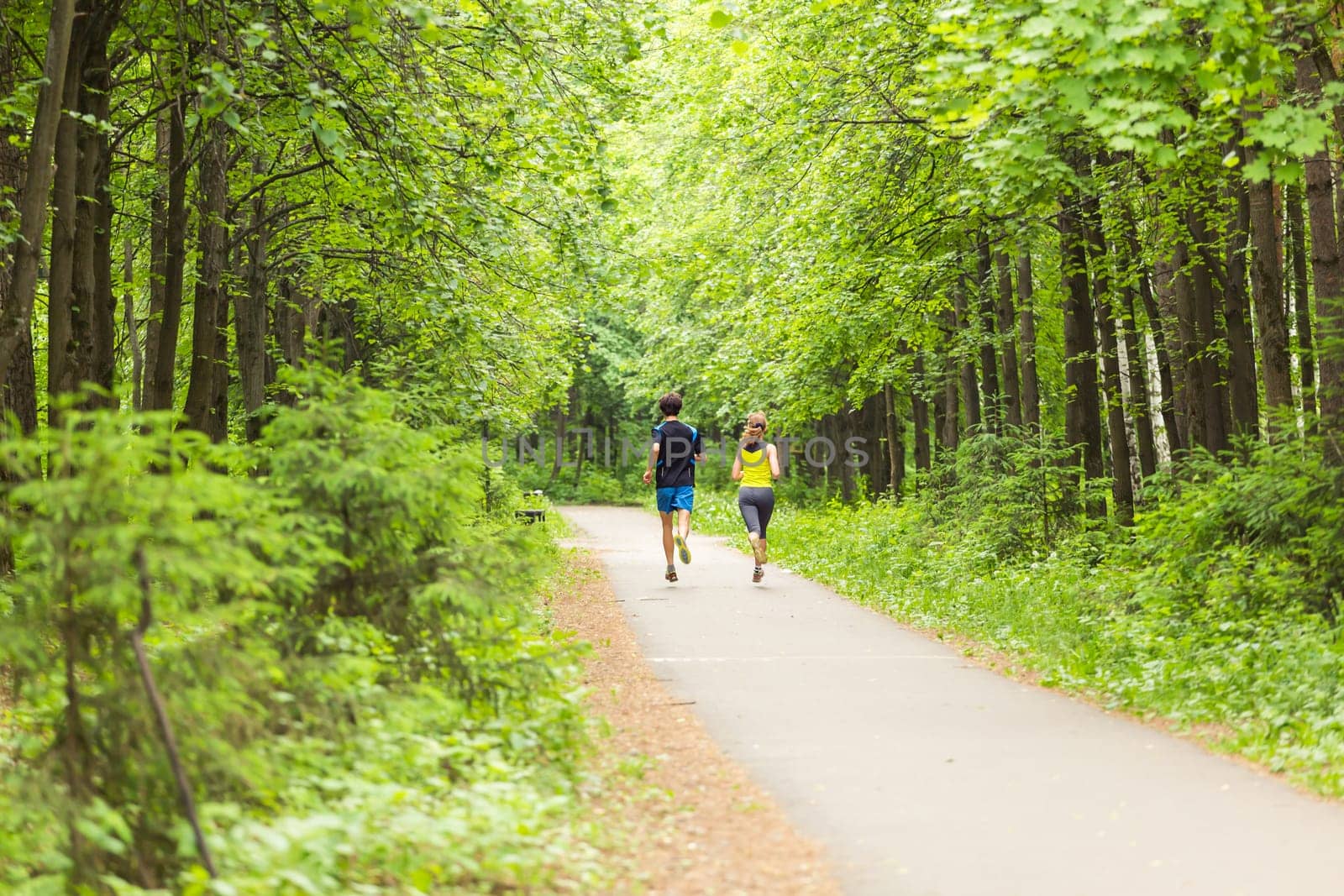 Young couple jogging in park at morning. Health and fitness concept.