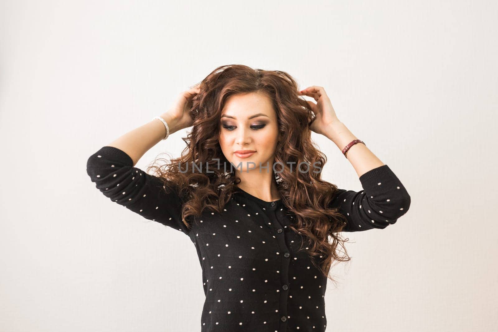 Young, beautiful girl looking into a mirror in beauty salon.