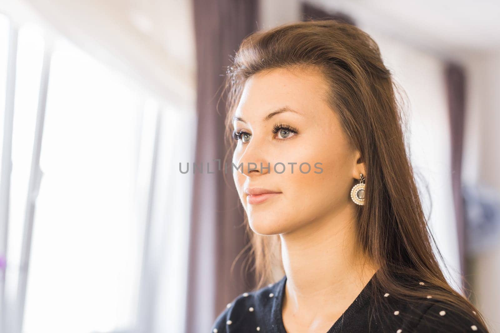 Young, beautiful girl looking into a mirror in beauty salon.