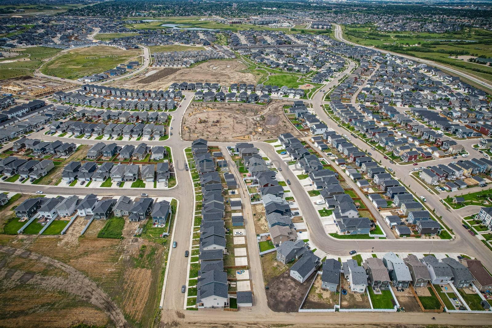 Elevated view of Rosewood neighborhood in Saskatoon, presenting a tapestry of urban design intertwined with Saskatchewan's serene natural canvas.