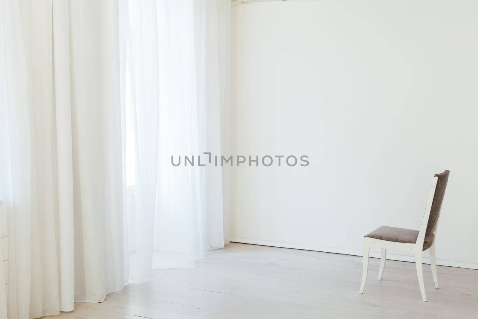 gray chair in the interior of an empty white room by Simakov