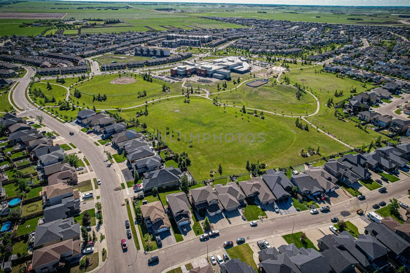 Elevated panorama of Willowgrove, showcasing the neighborhood's modern aesthetics intertwined with pockets of lush green, epitomizing Saskatoon's suburban beauty