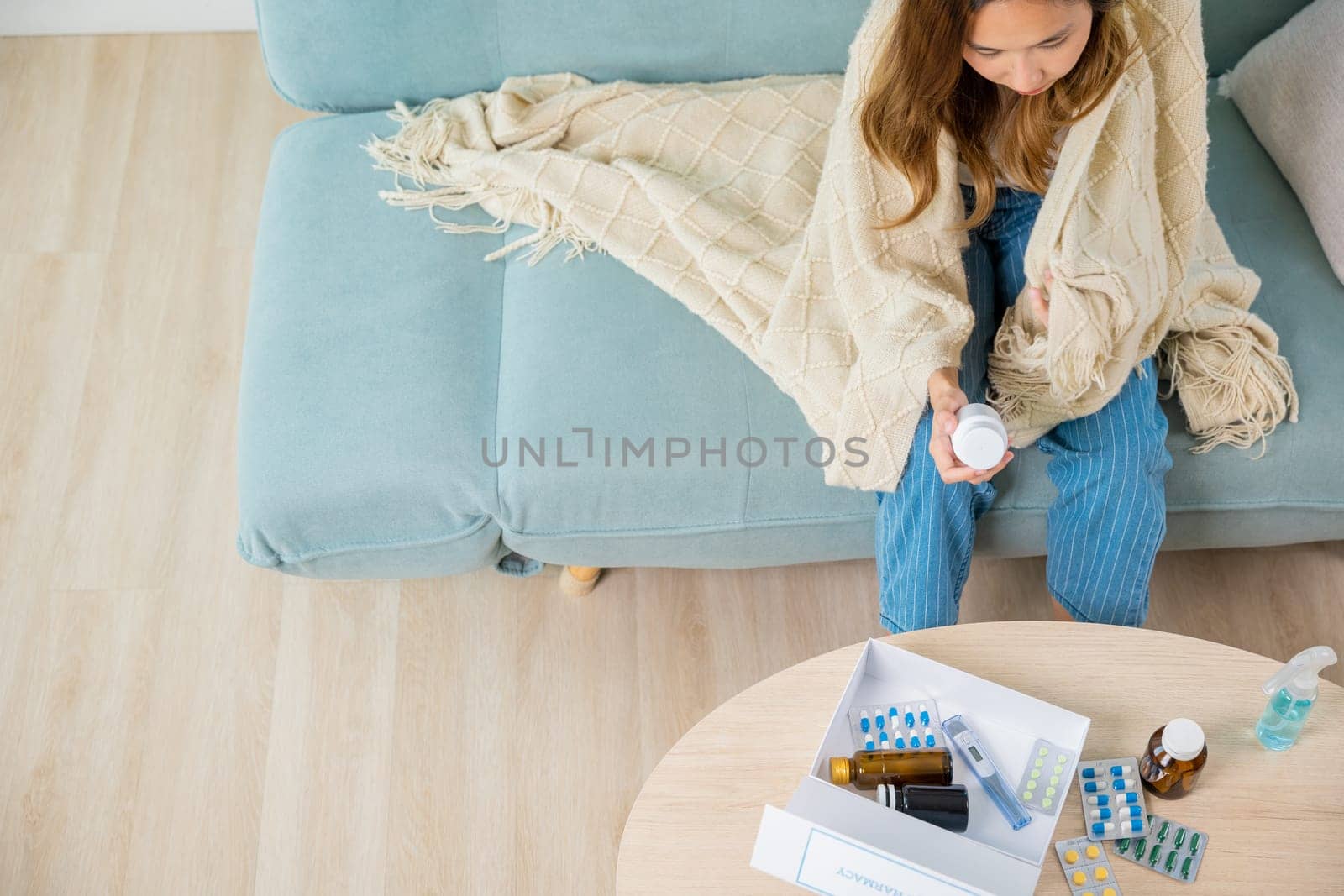 Sick ill young woman cold she covered blanket hold pills bottle read medicine prescription label, female checking ingredient information on sofa at house, pharmacy health care medicament concept