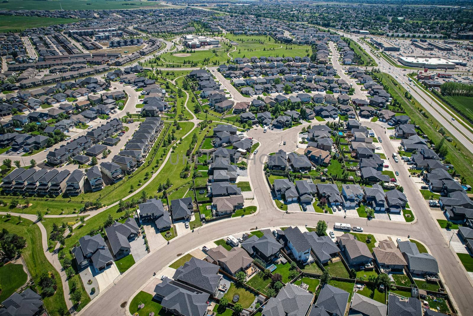 Elevated panorama of Willowgrove, showcasing the neighborhood's modern aesthetics intertwined with pockets of lush green, epitomizing Saskatoon's suburban beauty