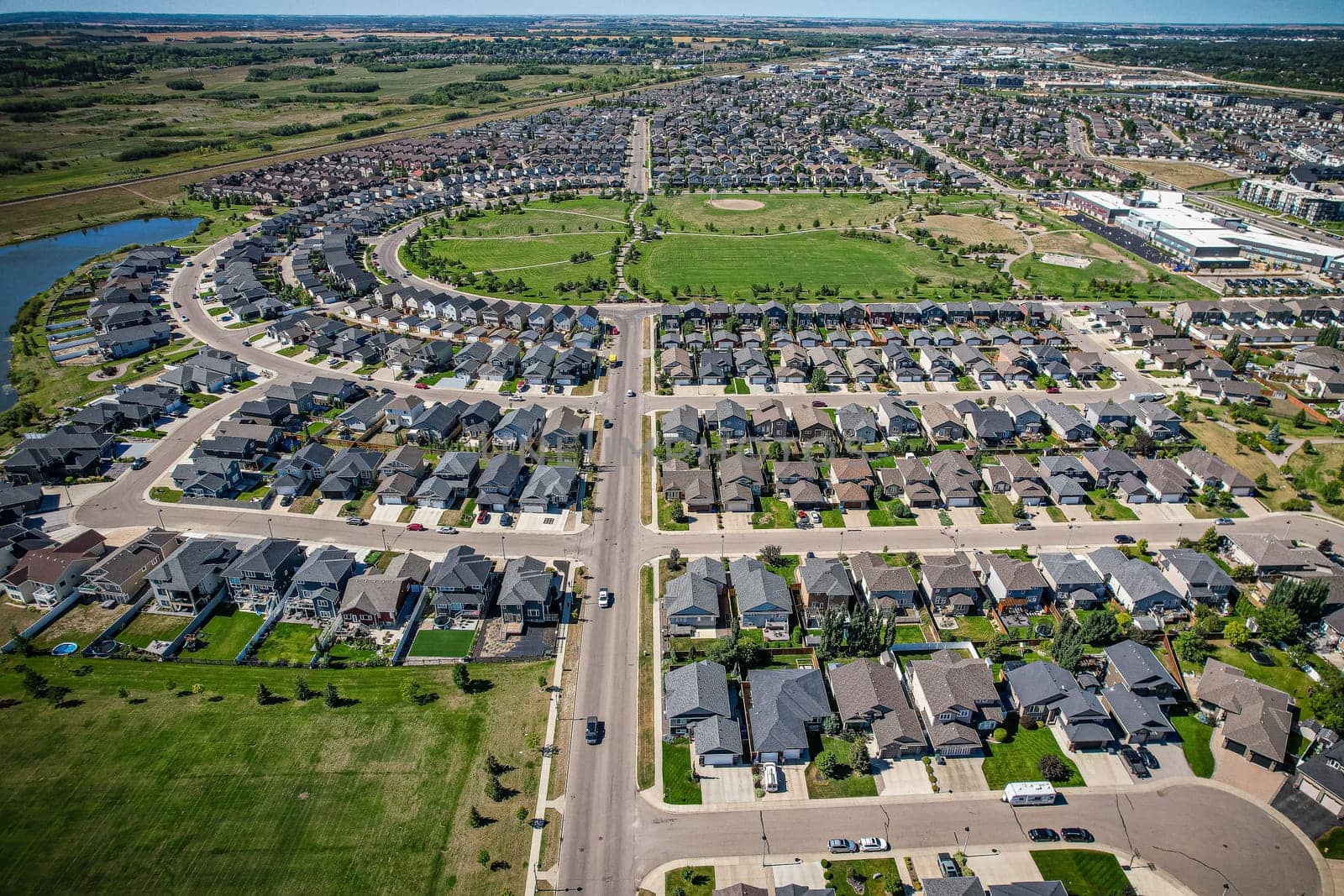Captivating aerial shot of Stonebridge in Saskatoon, highlighting the harmonious blend of modern architecture and Saskatchewan's verdant surroundings.