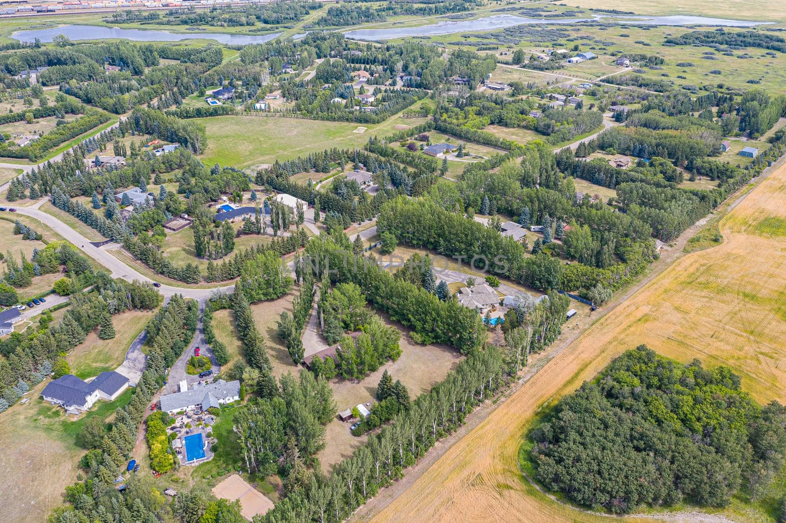 Experience the charm of Cedar Villa Estates from above. This drone image beautifully showcases the area's spacious estates, lush greenery, and tranquil setting, offering a unique aerial perspective of Saskatoon.
