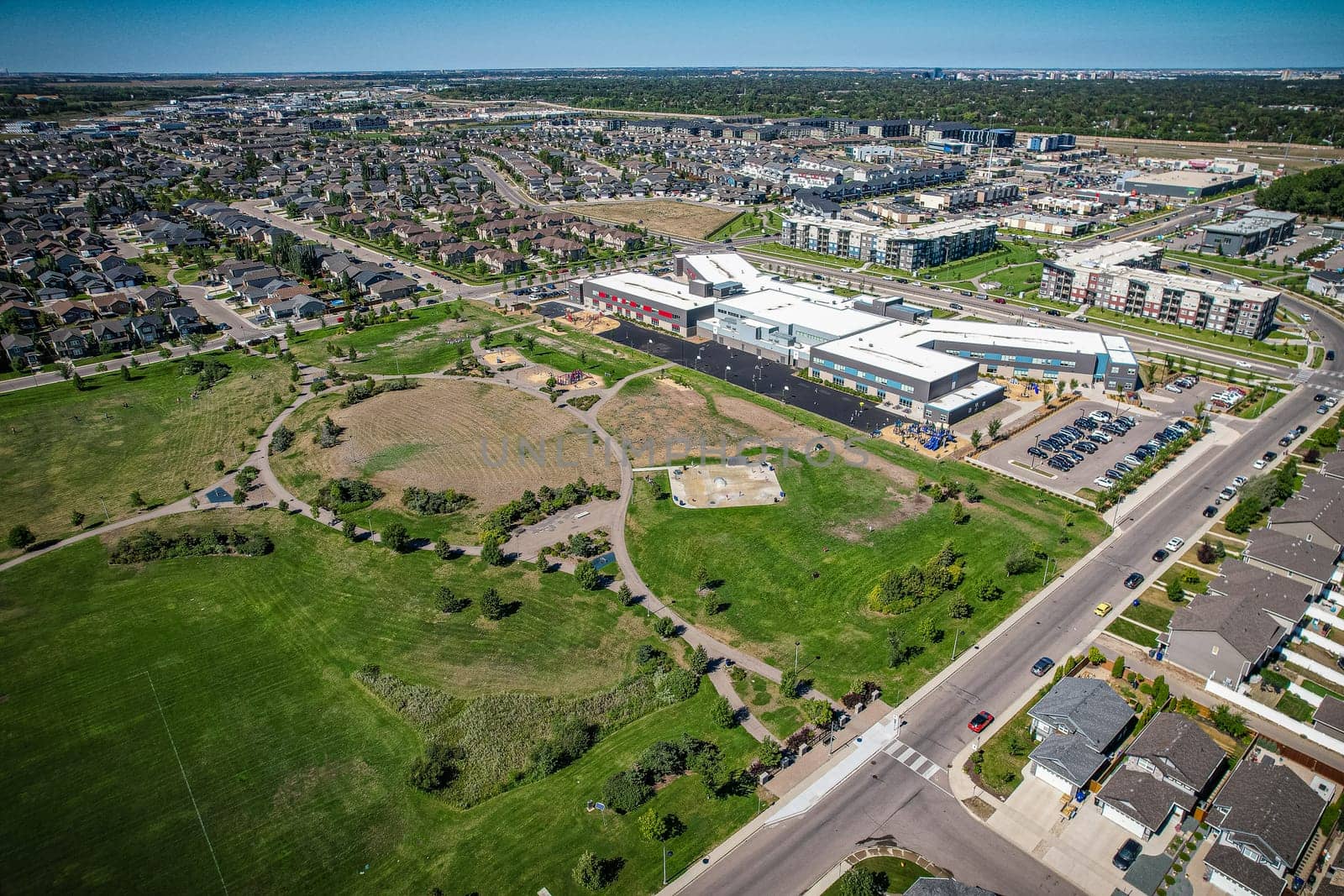 Captivating aerial shot of Stonebridge in Saskatoon, highlighting the harmonious blend of modern architecture and Saskatchewan's verdant surroundings.