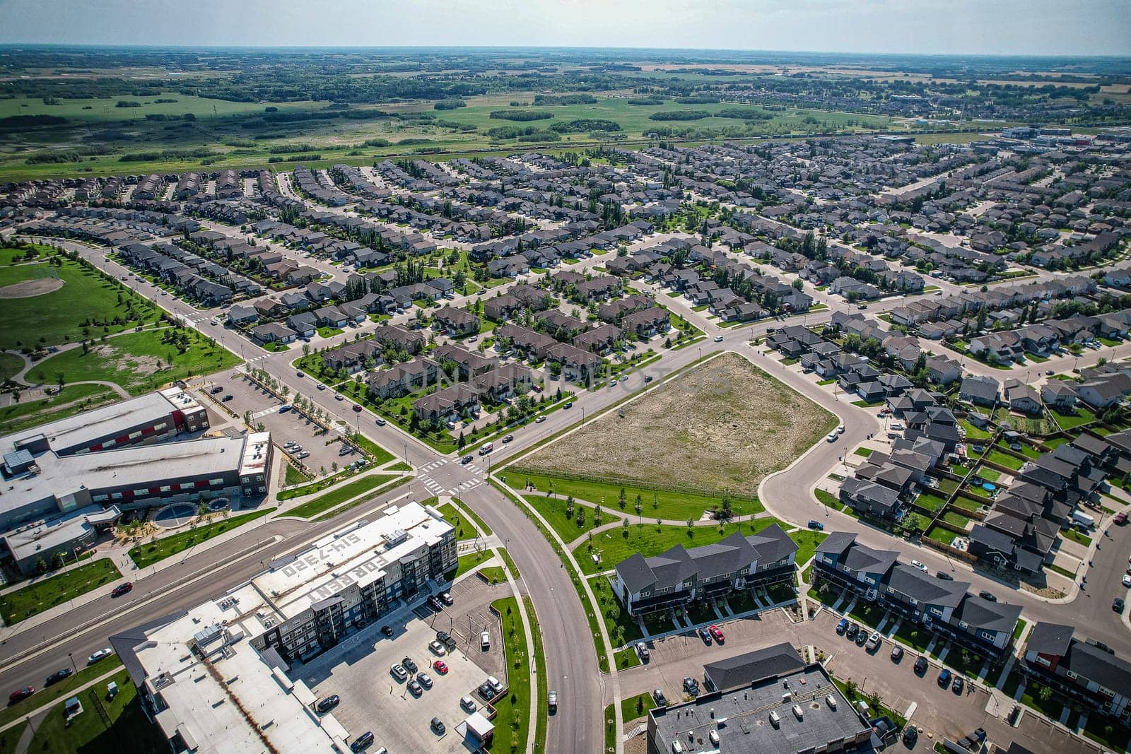 Captivating aerial shot of Stonebridge in Saskatoon, highlighting the harmonious blend of modern architecture and Saskatchewan's verdant surroundings.