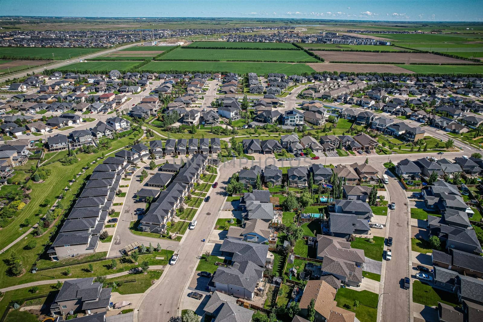 Elevated panorama of Willowgrove, showcasing the neighborhood's modern aesthetics intertwined with pockets of lush green, epitomizing Saskatoon's suburban beauty