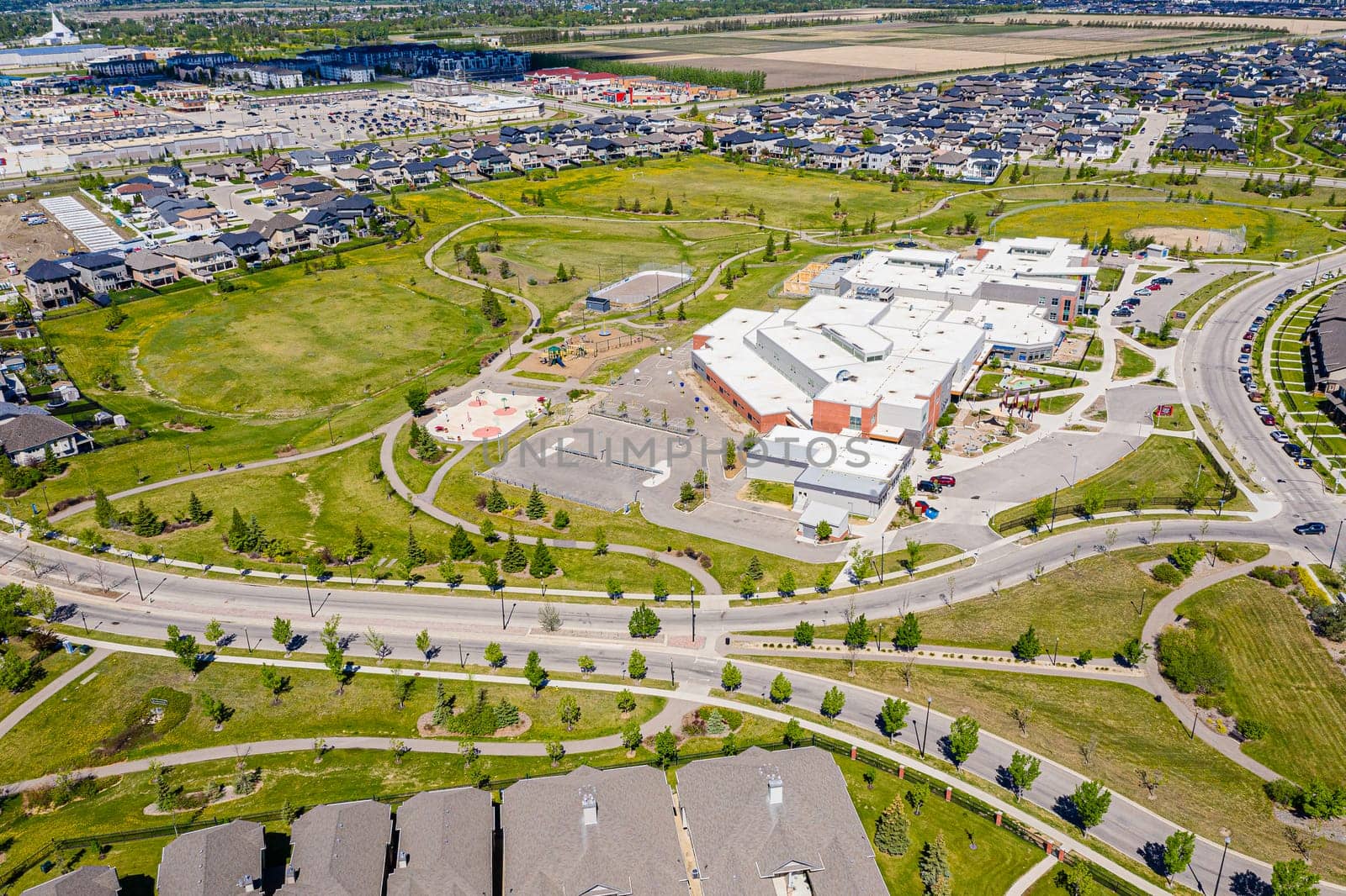 Aerial image of Willowgrove, Saskatoon, SK, showcasing its modern homes, intricate pathways, and lush parks. A neighborhood echoing family-centric living. Ideal for urban planning and real estate.