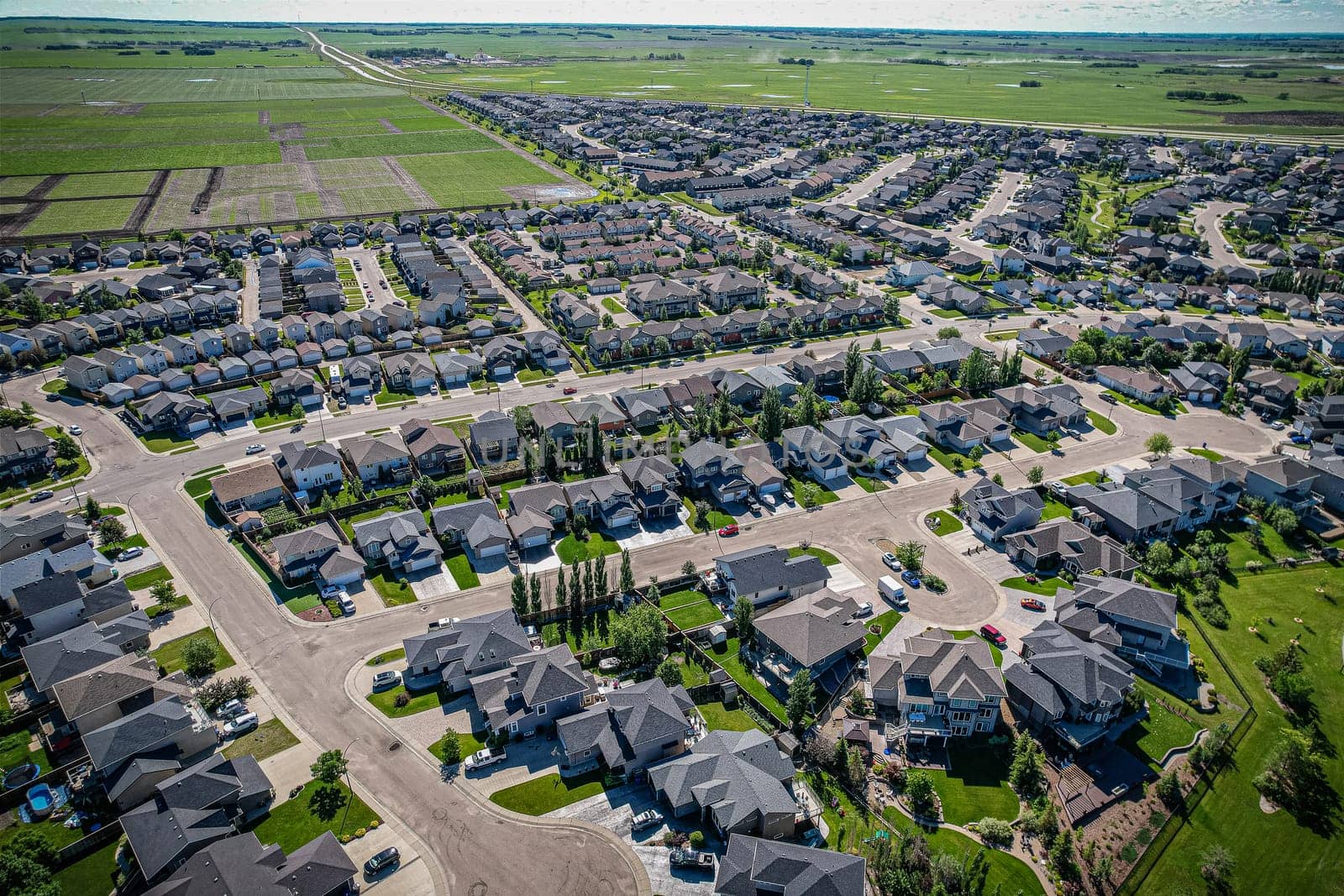 Elevated panorama of Willowgrove, showcasing the neighborhood's modern aesthetics intertwined with pockets of lush green, epitomizing Saskatoon's suburban beauty