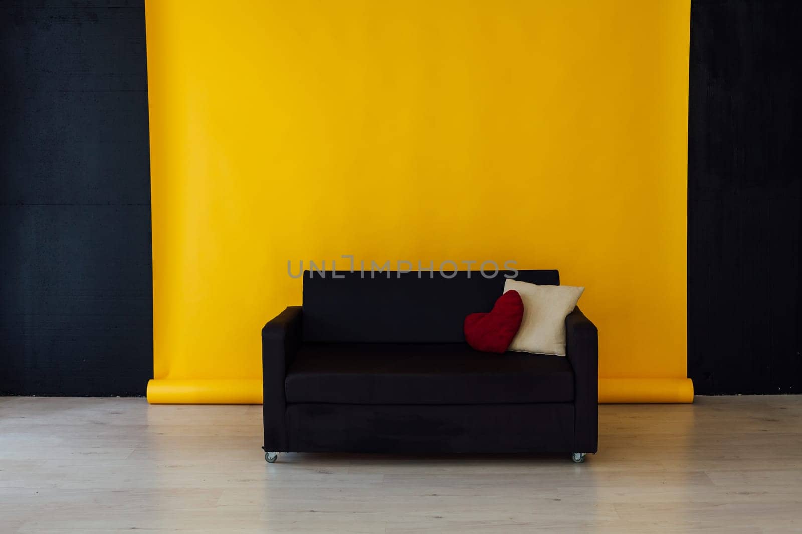 black sofa in the interior of the room with a yellow background by Simakov