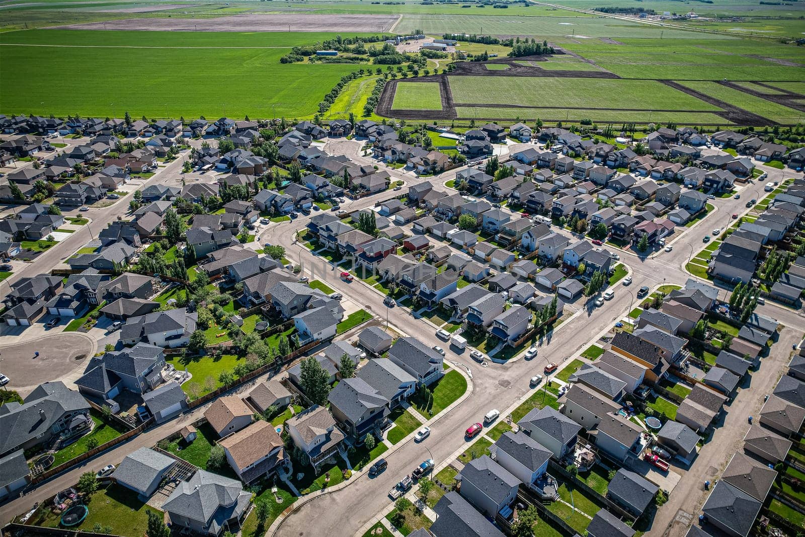 Elevated panorama of Willowgrove, showcasing the neighborhood's modern aesthetics intertwined with pockets of lush green, epitomizing Saskatoon's suburban beauty
