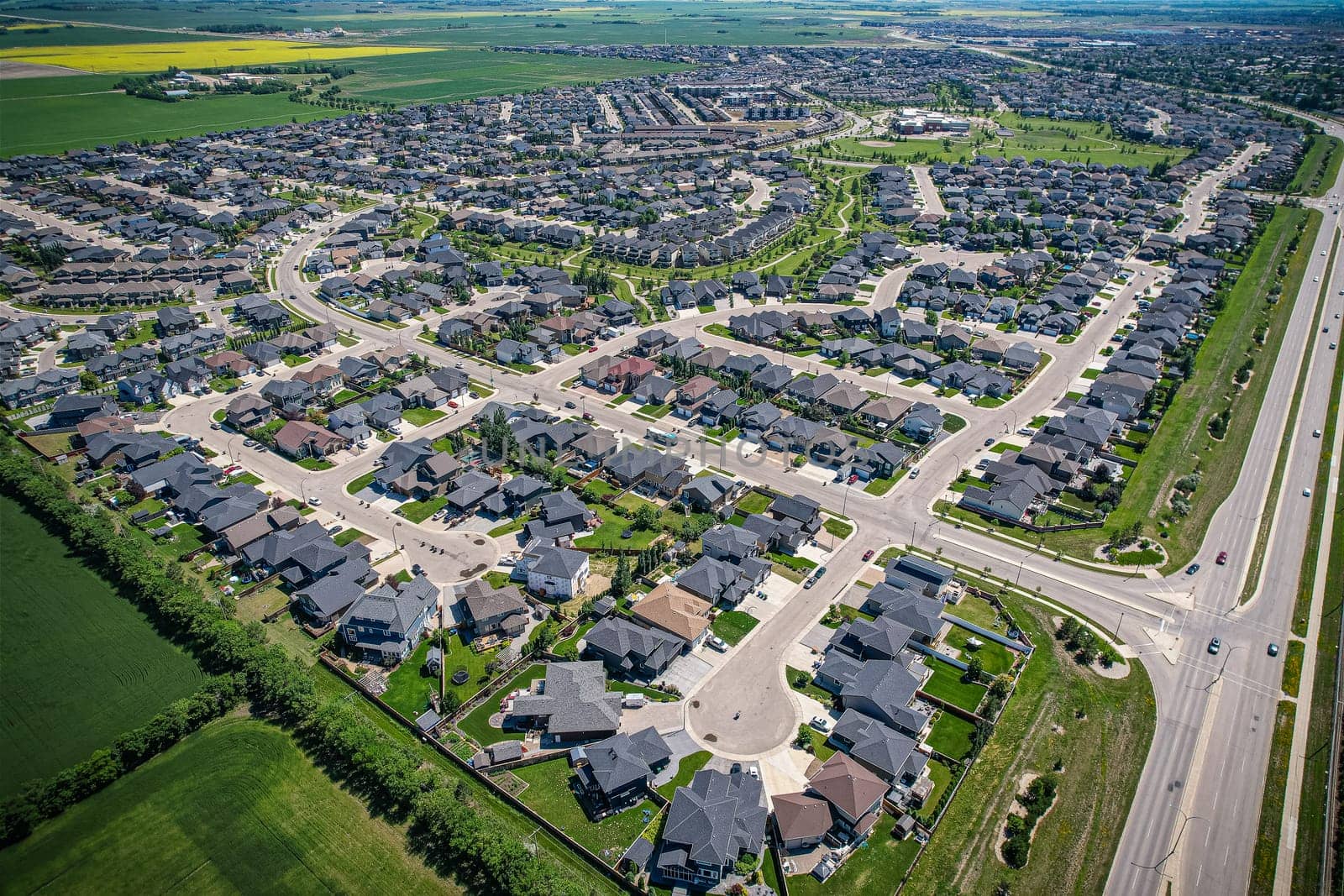 Elevated panorama of Willowgrove, showcasing the neighborhood's modern aesthetics intertwined with pockets of lush green, epitomizing Saskatoon's suburban beauty