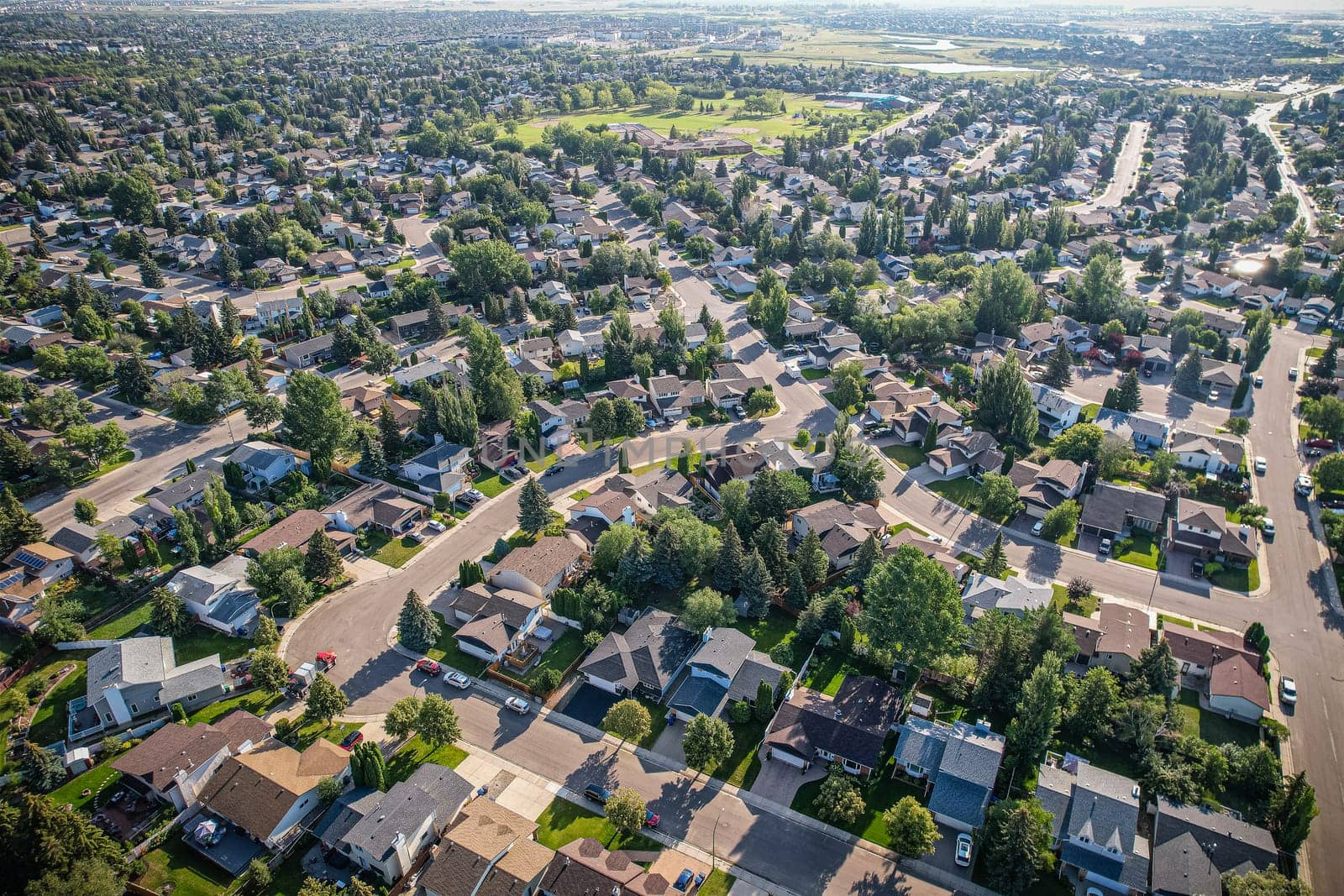 Soaring over Lakeview in Saskatoon, this bird's-eye capture magnifies the neighborhood's tranquil waters, verdant parks, and the serene rhythm of Saskatchewan living