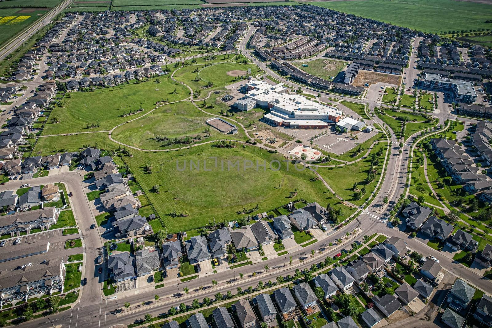 Elevated panorama of Willowgrove, showcasing the neighborhood's modern aesthetics intertwined with pockets of lush green, epitomizing Saskatoon's suburban beauty