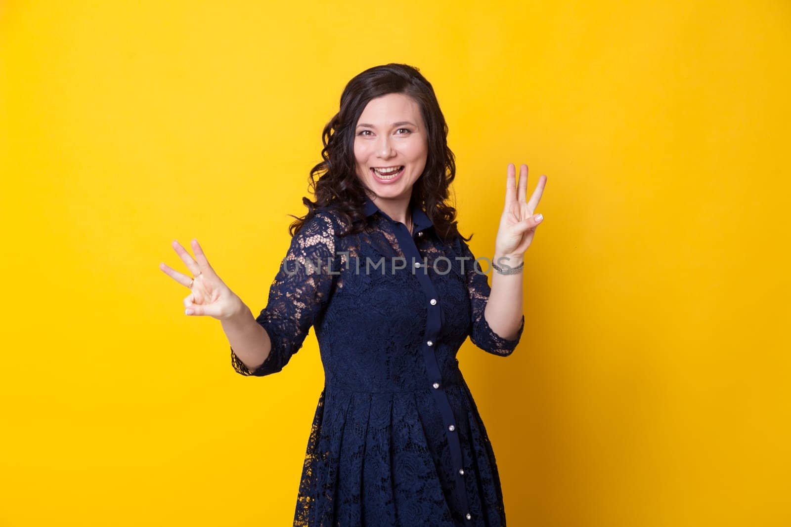 portrait of a beautiful woman in a blue dress against a yellow background