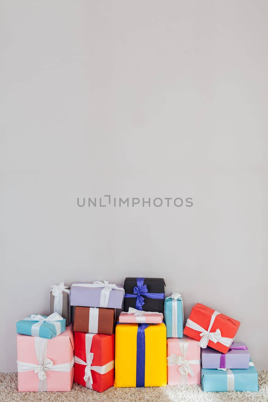 lots of multi-colored gifts on a grey festive background by Simakov