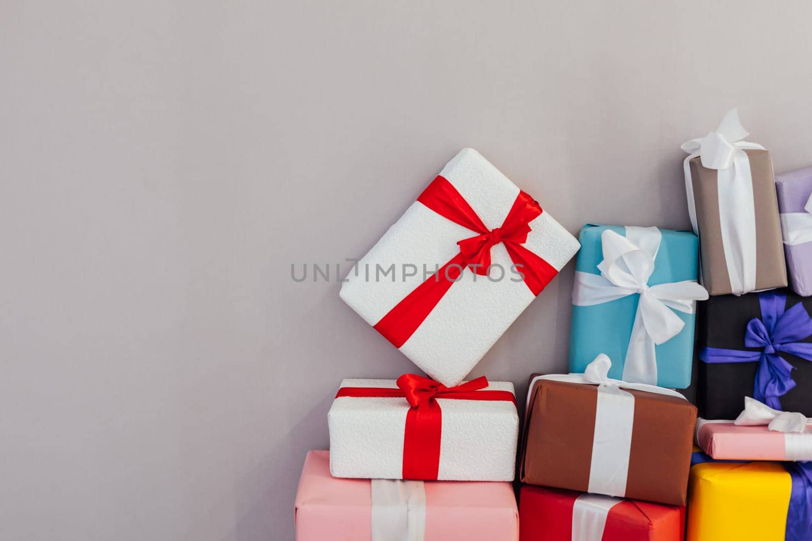 lots of multi-colored gifts on a grey festive background by Simakov