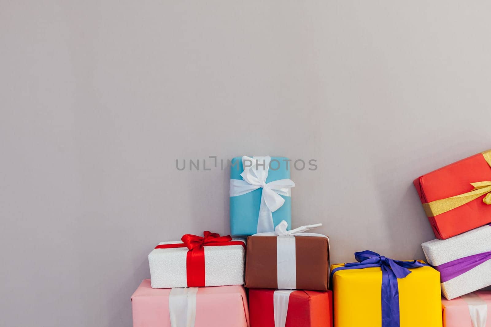 lots of multi-colored gifts on a grey background