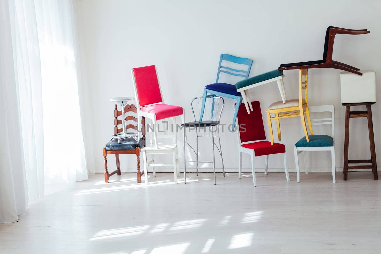 many multicolored chairs in the mess of the white room moving