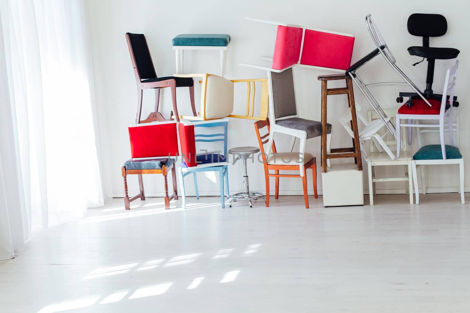 many multicolored chairs in the mess of the white room moving