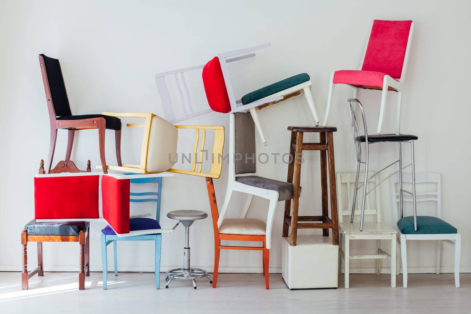 many multicolored chairs in the mess of the white room by Simakov