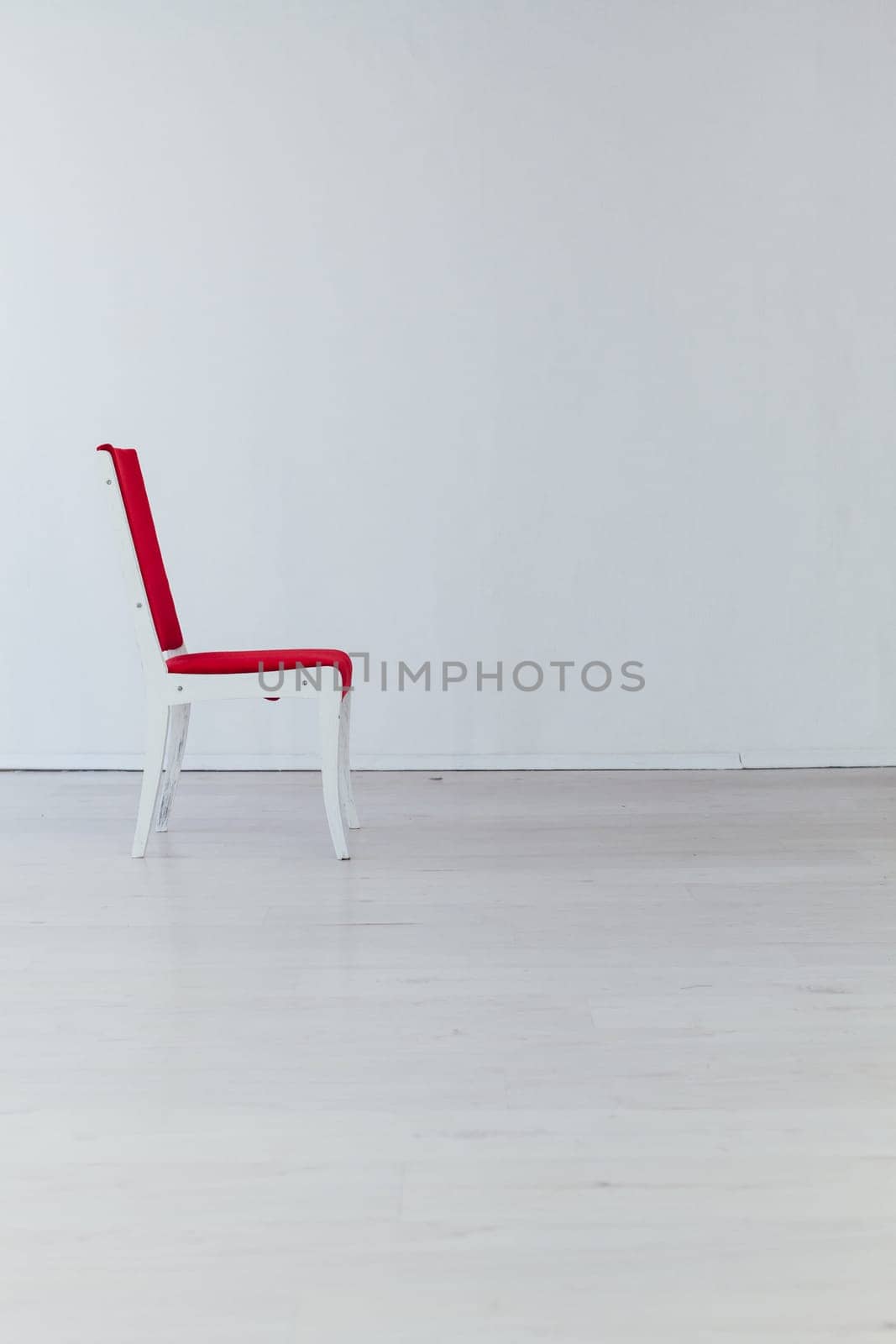 red vintage chair in the interior of an empty white room by Simakov