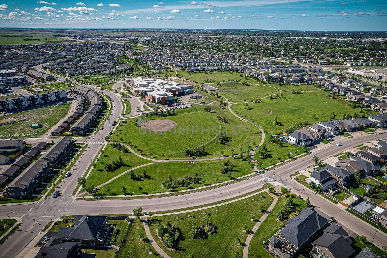 Elevated panorama of Willowgrove, showcasing the neighborhood's modern aesthetics intertwined with pockets of lush green, epitomizing Saskatoon's suburban beauty
