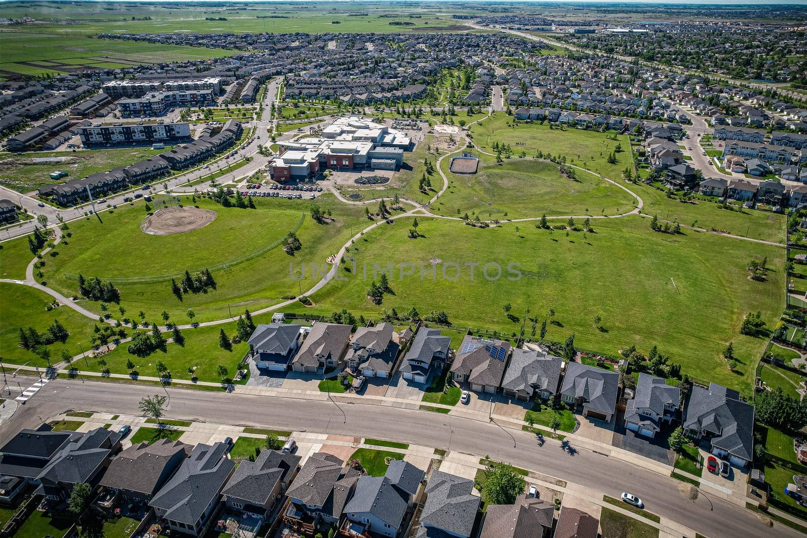 Elevated panorama of Willowgrove, showcasing the neighborhood's modern aesthetics intertwined with pockets of lush green, epitomizing Saskatoon's suburban beauty